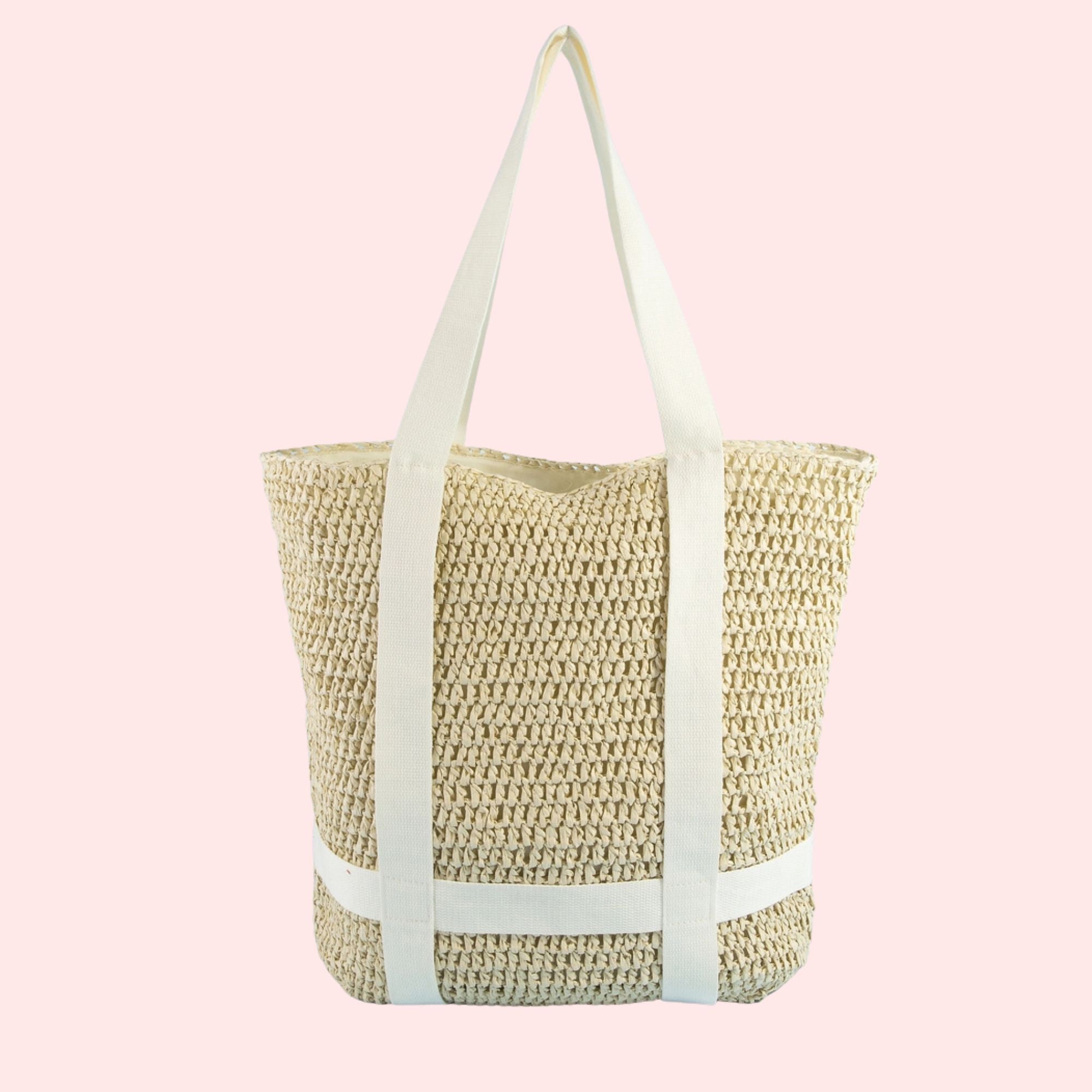 Woven straw tote bag with light blue straps on a pink background