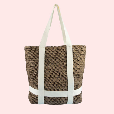 Woven tote bag with white straps on a pink background